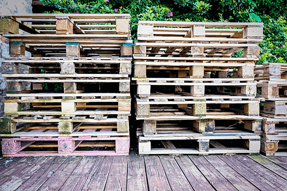 three stacks of wooden pallets on stored on a deck