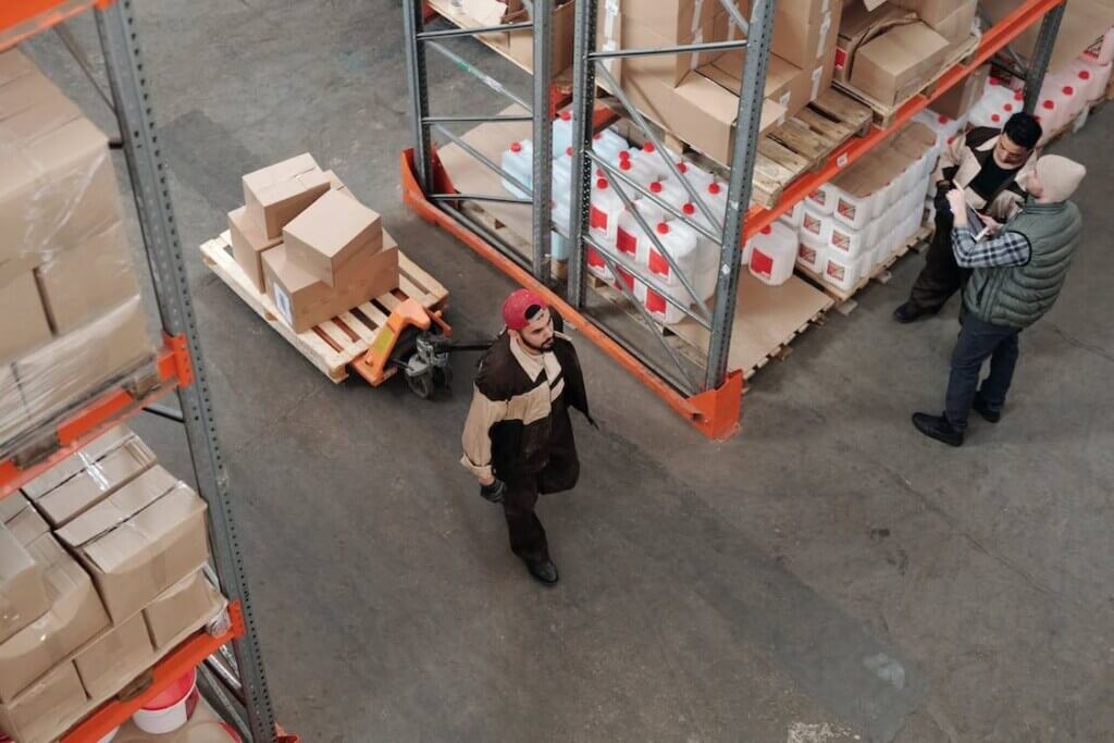 worker pulling pallet jack through warehouse