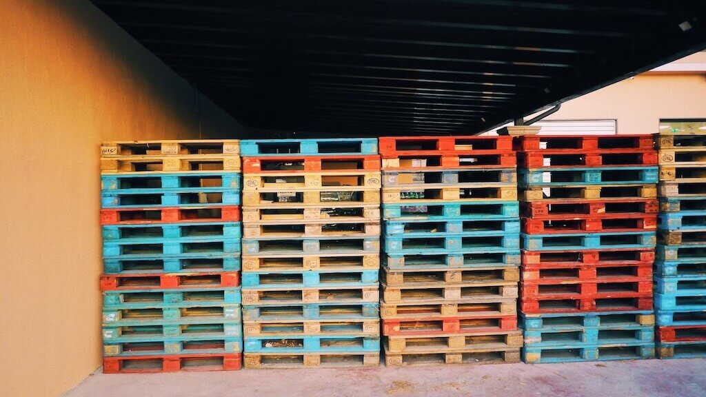 stacks of wooden pallets of various colours